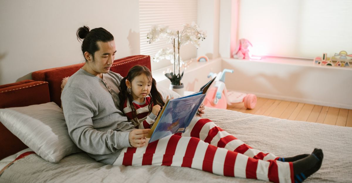 Parent and child reading together at home in natural light, representing everyday parenting and family connection.