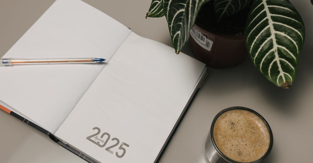 Open planner with coffee and a small plant on a warm desk, representing the daily rhythm of a family law office.