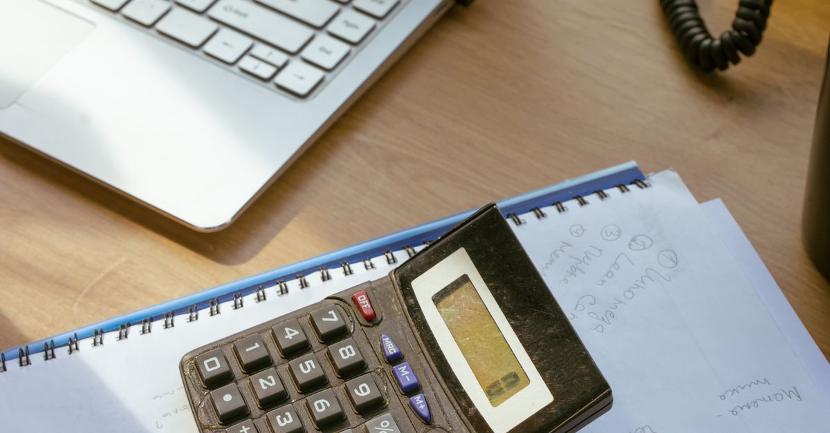 Couple organizing financial papers and a calculator at home, representing the records gathered before a divorce case.